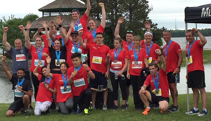 Smiling Honda Waterfront Run participants in red t-shirts pose for a photo